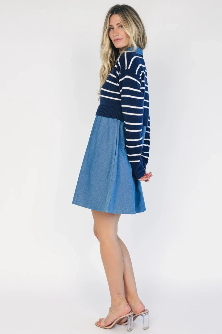 Model wearing a navy and ivory striped sweater dress with a collared neckline, functional button-front detail, long sleeves, and an elastic waist.