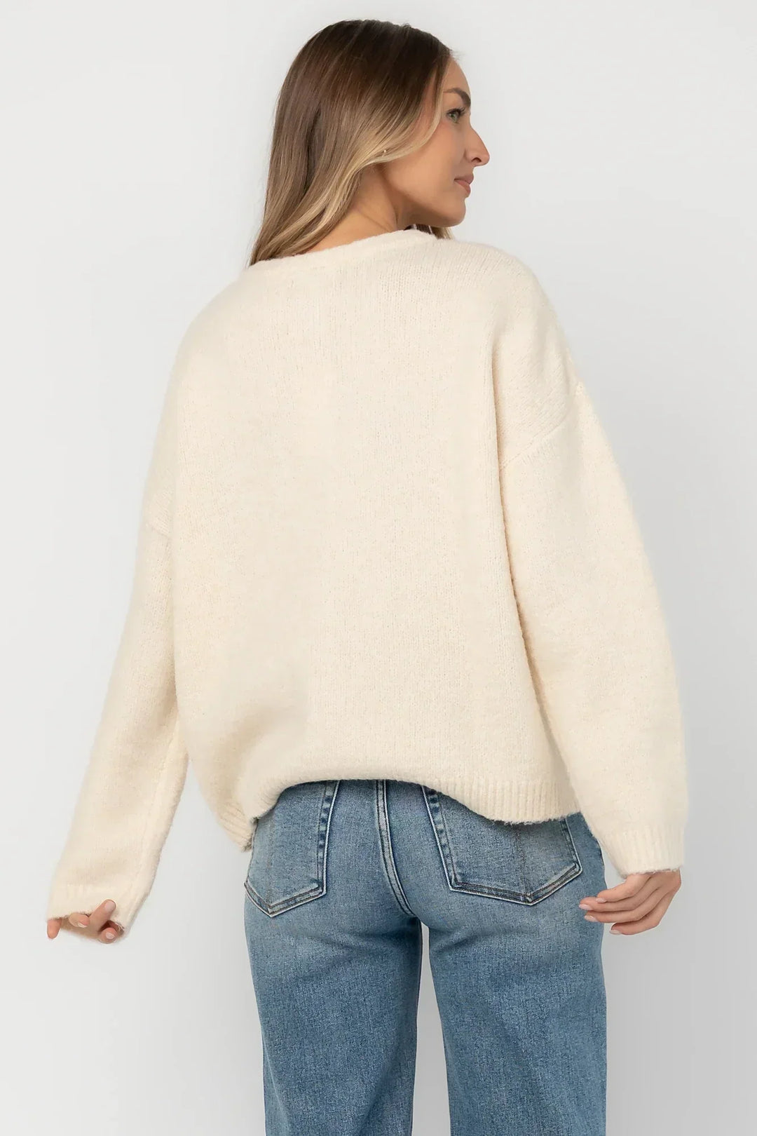 Cream fuzzy knit cardigan with a round neckline, button-front closure, long sleeves, dropped shoulders, and a relaxed fit.