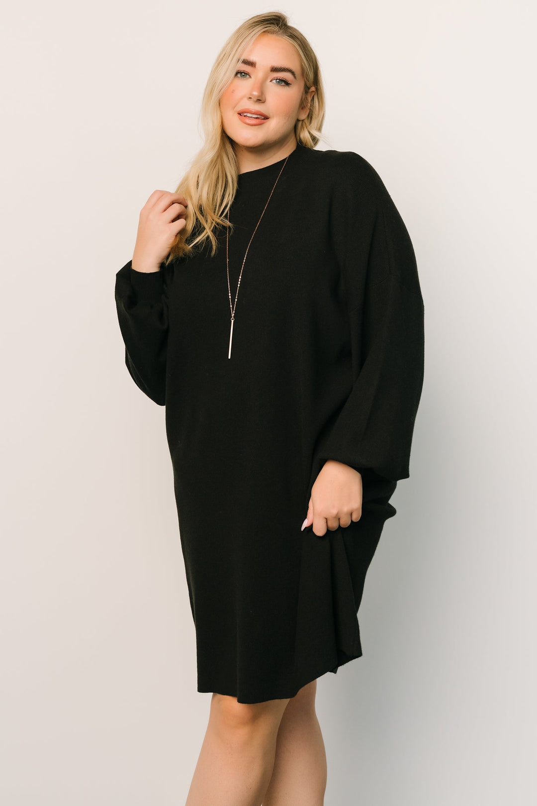 Model walking in the black sweater dress, highlighting movement, soft drape of the viscose blend, and the versatile short silhouette.